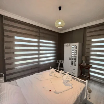 Modernes Schlafzimmer mit zwei Betten, eleganter Treppe, neutralen Farben und heller Beleuchtung